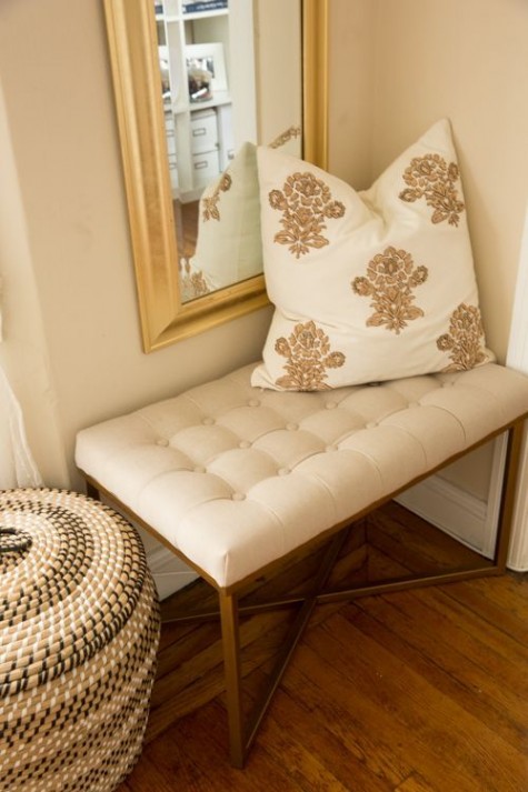 a small upholstered bench and a mirror for an entryway nook