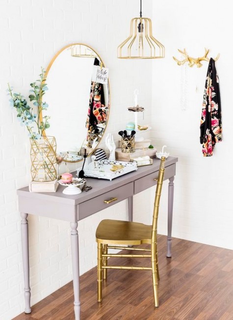 a vintage grey vanity, a gilded chair, lamp and mirror and geometric touches