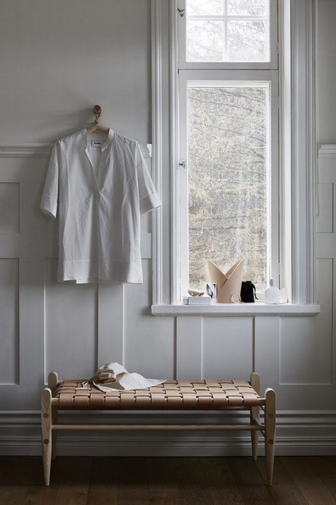a woven leather bench with a wooden frame