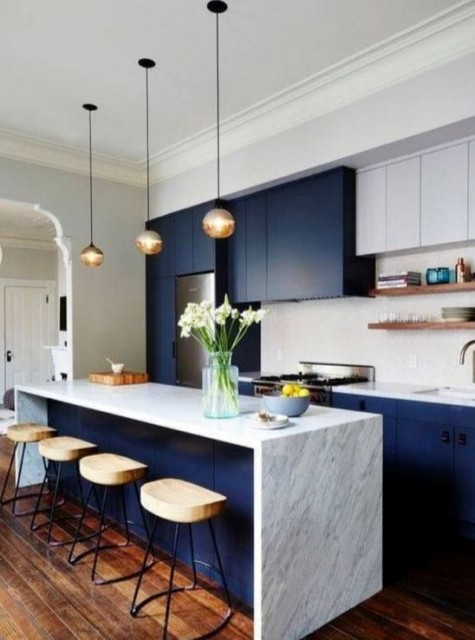 bold blue and white cabinets plus a marble kitchen island look modern and luxurious