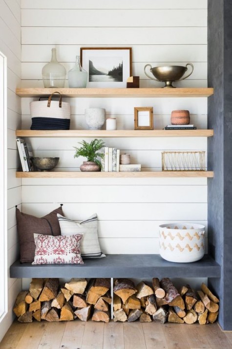 light-colored wooden shelves over a built-in concrete seat and firewood storage