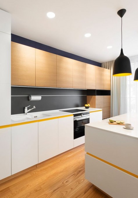 white and light-colored wood cabinets and a matte black backsplash and lamps