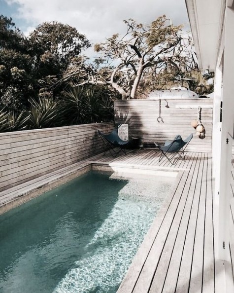 a boho deck with a long narrow pool and a couple of chairs