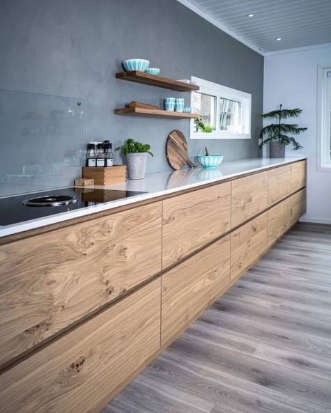 a contemporary kitchen with wooden cabients and a concrete backsplash plus a glass cover over it