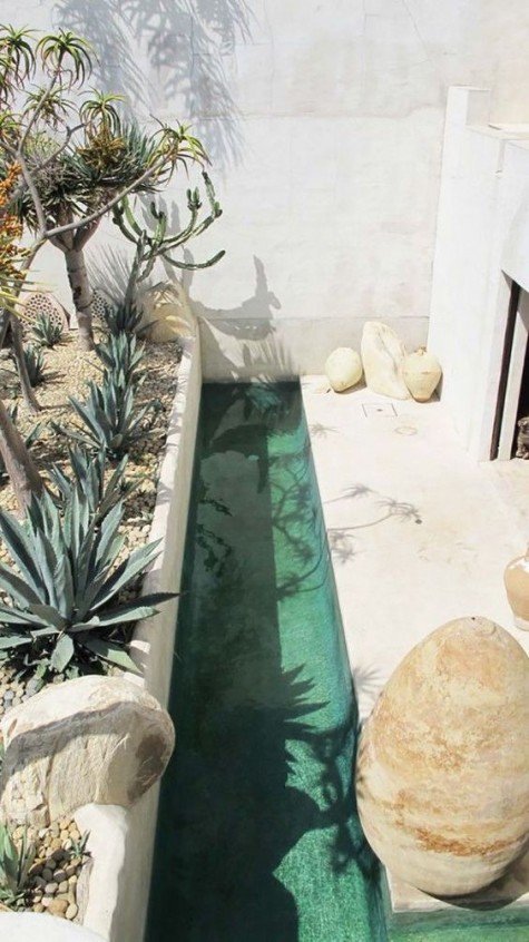 a desert-style patio with a long and very narrow pool for refreshing