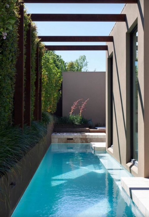 a long and narrow pool is squeezed between the house and the outer wall