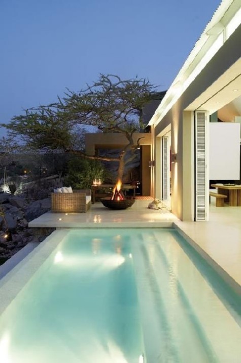 a modern house with a long outdoor pool with built-in lights