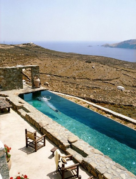 a natural terrace with a view and a long narrow pool clad with stone