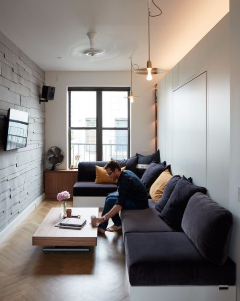 a small living room with a large corner sofa and some smaller items