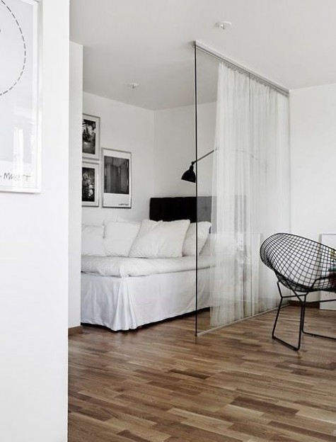 a small sleeping space with a large bed and some artworks