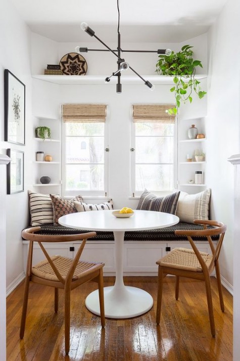 a tiny dining space with built-in shelves and a bench with storage drawers