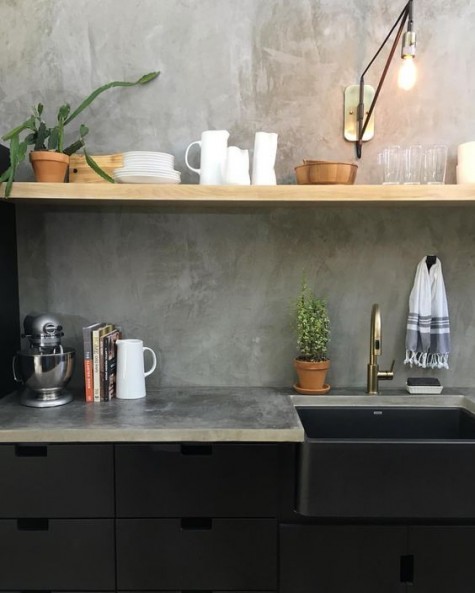 black industrial cabinets, wooden shelves and a concrete backsplash and countertops