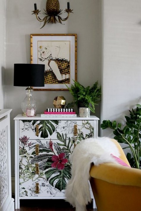 a tropical leaf and blooms dresser with leather and metallic handles