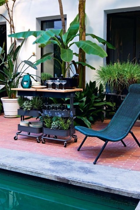 an outdoor bar in black with a wooden countertop using two IKEA Raskog carts for storage