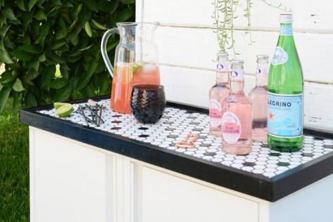 an outdoor bar with a mosaic top made of IKEA Josef cabinets