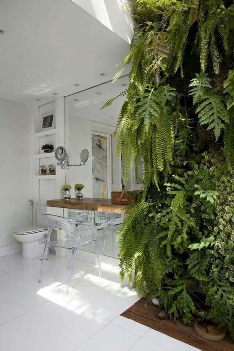 an ultra modern bathroom with a lush fern wall to bring outdoors indoors