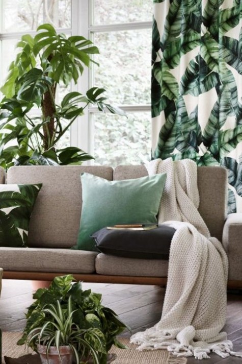 tropical leaf curtains and pillows spruce up the neutral space and give it a summer-like look
