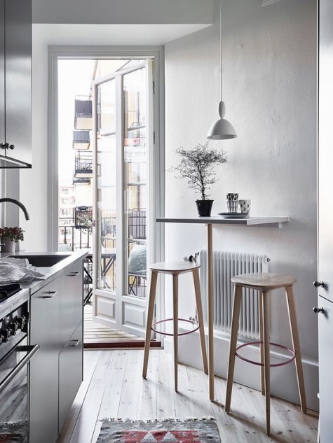 a Scandinavian kitchen with a small tabletop and wooden stools