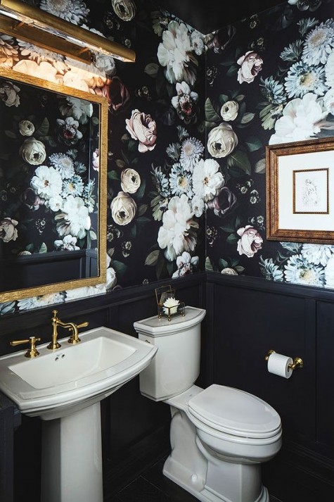 a chic powder room done with moody realistic floral wallpaper and black wainscoting