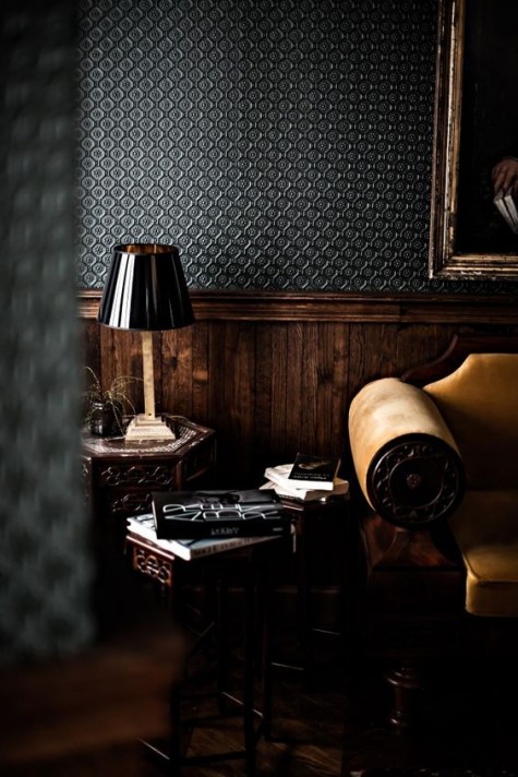 a moody masculine space done with dark printed wallpaper and dark-stained wainscoting