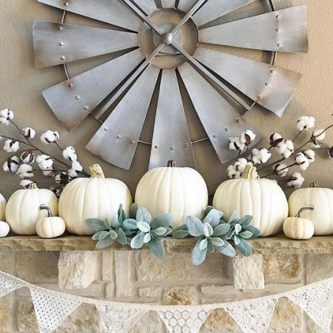 a neutral fall mantel with white pumpkins, greenery and cotton