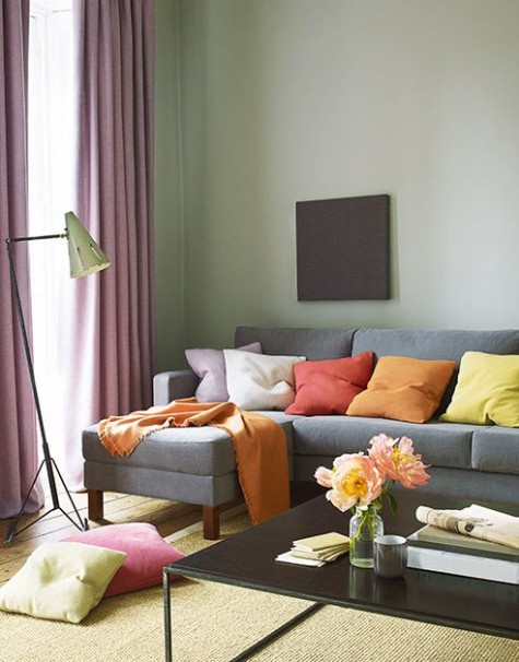 a pastel living room with fall-colored pillows as bold accents