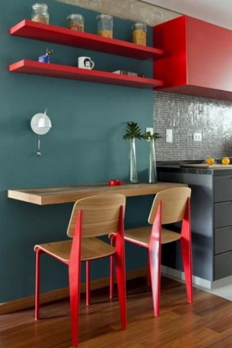 a small colorful breakfast space with a wall-mounted tabletop and shelves over it