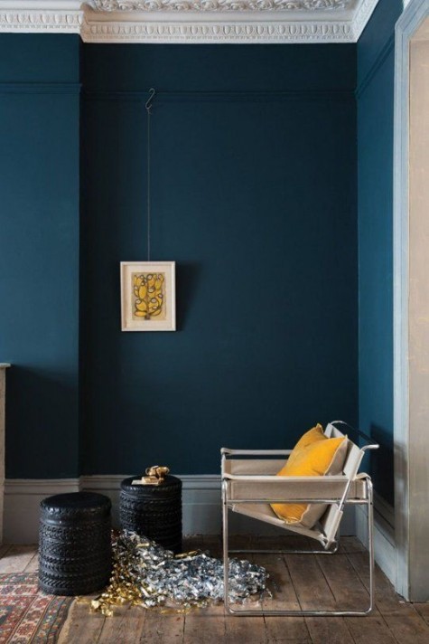 a statement navy wall and a saffron yellow pillow