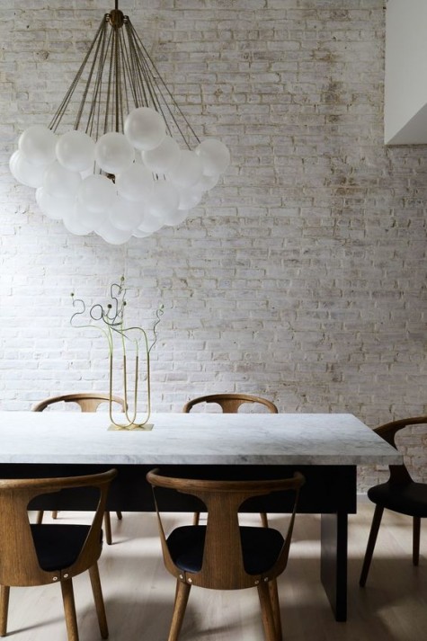 a whitewashed brick wall brings a raw touch to this elegant space