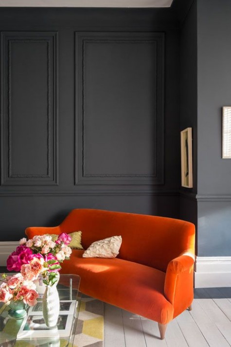 graphite grey wainscoting creates a moody ambience and colorful furniture spruces it up