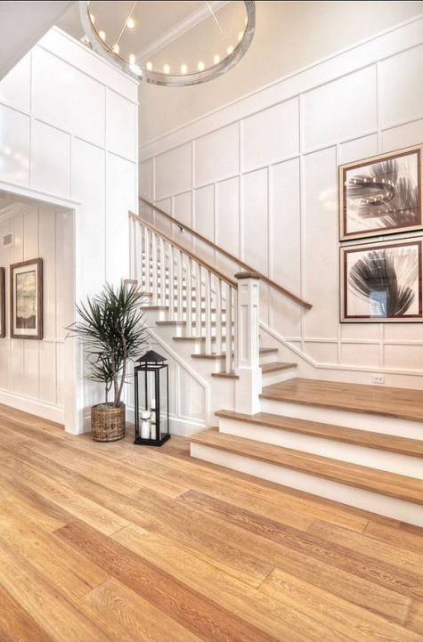 white molded walls loook cool with light-colored wood and a gorgeous chandelier makesthem cooler