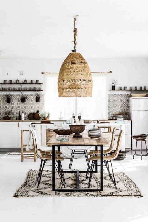 a boho tropical kitchen with a wicker lampshade, a boho rug, rattan chairs, a mosaic tile backsplash