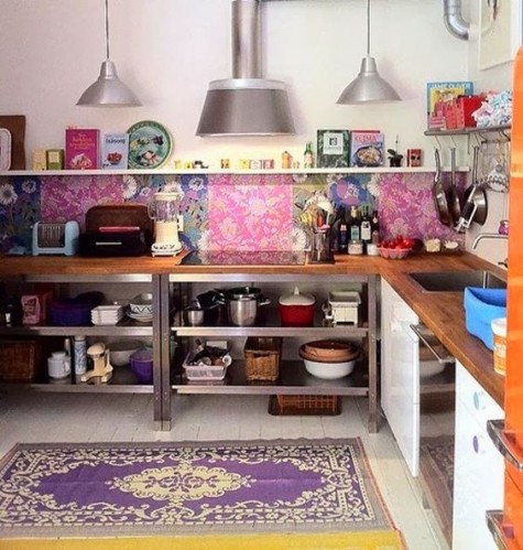 a colorful Morocco-inspired kitchne with a bright tile backsplash and a bold printed rug