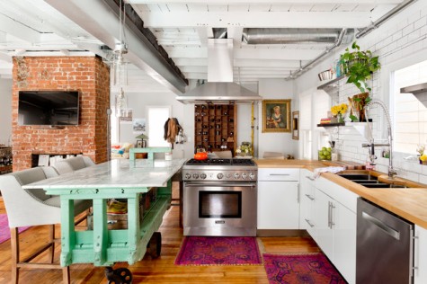 bold printed rugs, an aqua kitchen island and some potted greenery for a boho feel